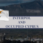 A landscape view of Cyprus with coastal mountains, used to illustrate INTERPOL, extradition issues, and the occupied area of Northern Cyprus.